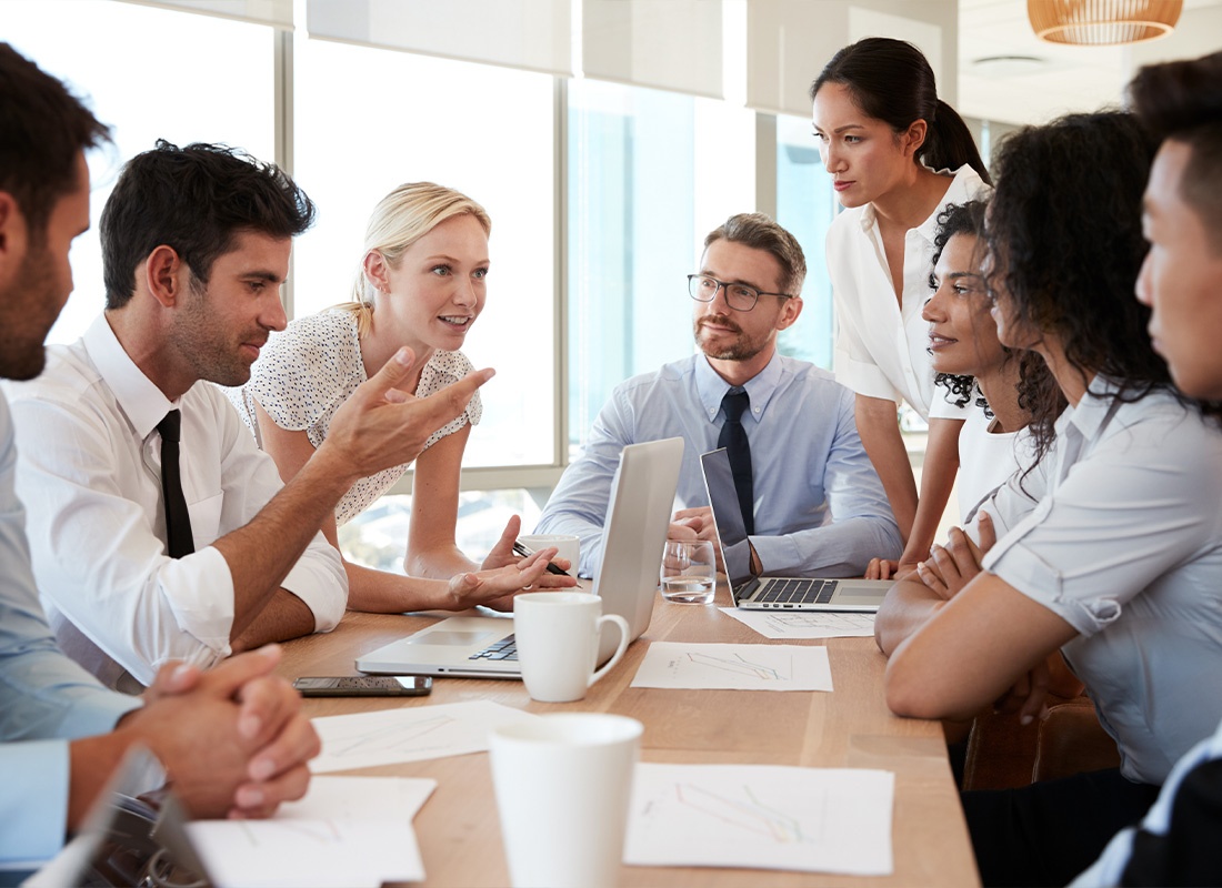 Business Insurance - Group of Businesspeople Meeting Around a Table in Office